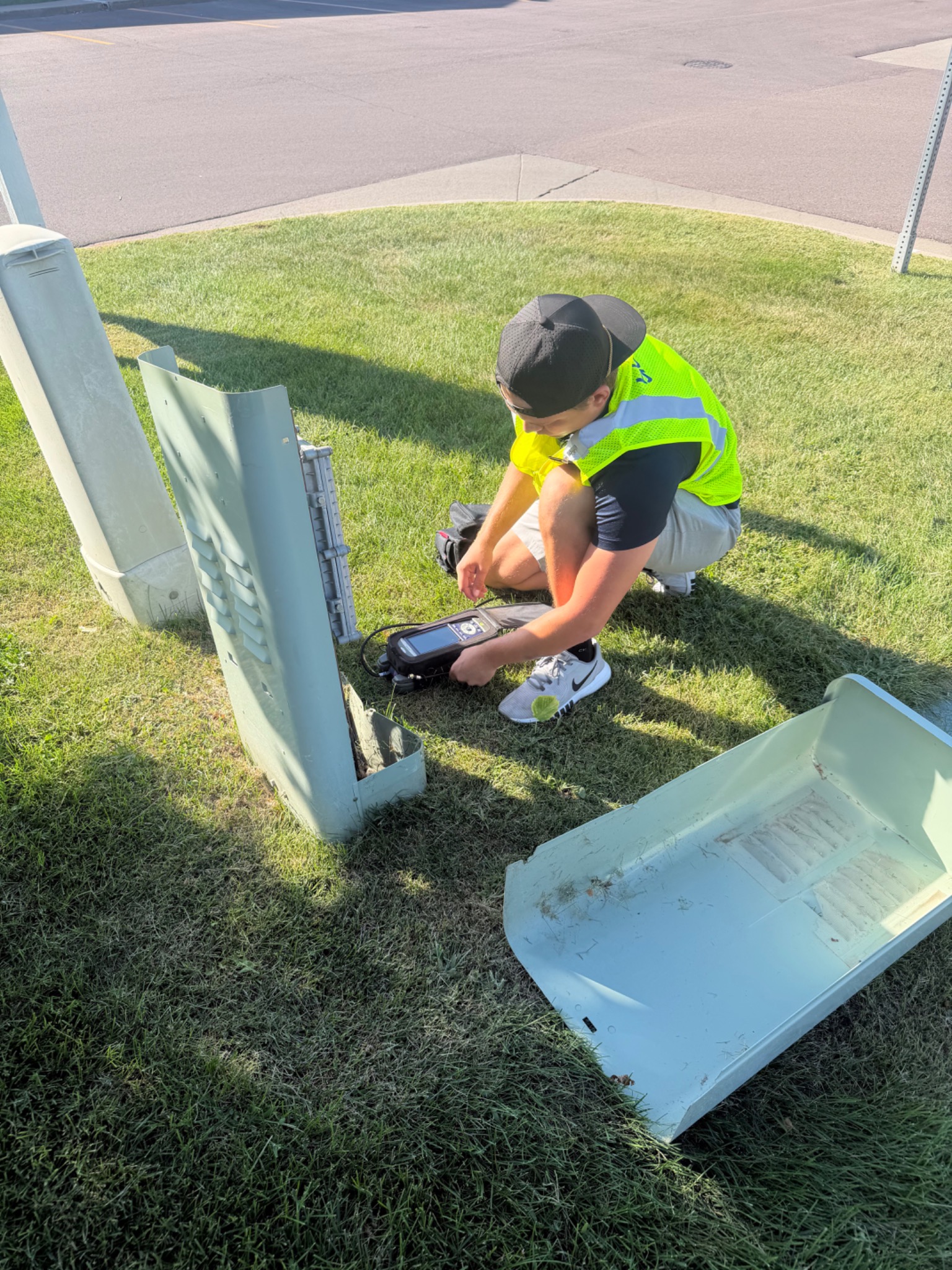 Prodigy Gold technician working with field equipment beside an open utility pedestal